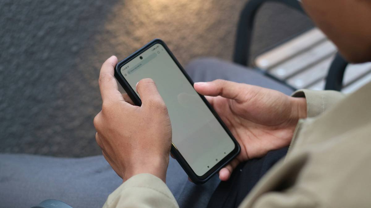 A close-up view of hands holding and navigating a smartphone. This image captures the essence of modern technology and daily digital interaction. Perfect for illustrating concepts of connectivity, mobile usage, or lifestyle in the digital age