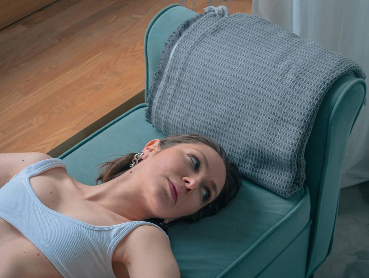 a woman laying on a couch with a pillow